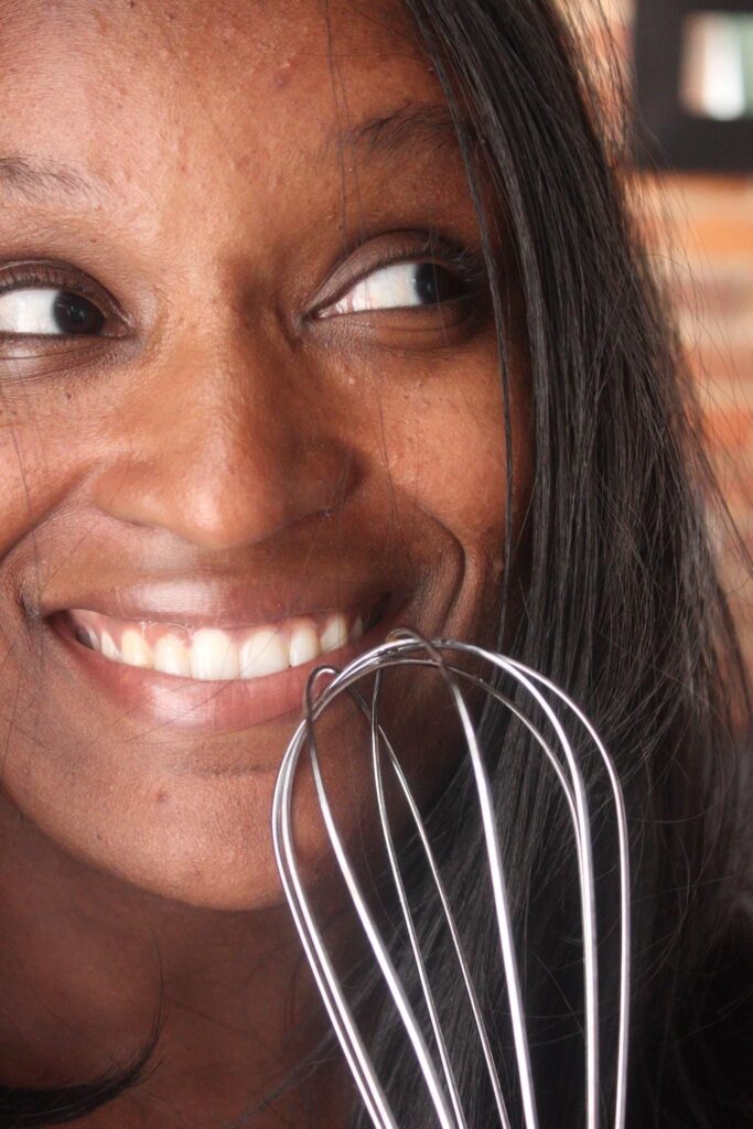 Nicole Washington holding a whisk and smiling