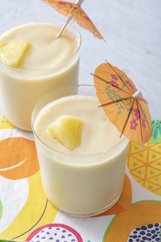 Two One Potato tropical smoothies with pineapple and paper umbrellas