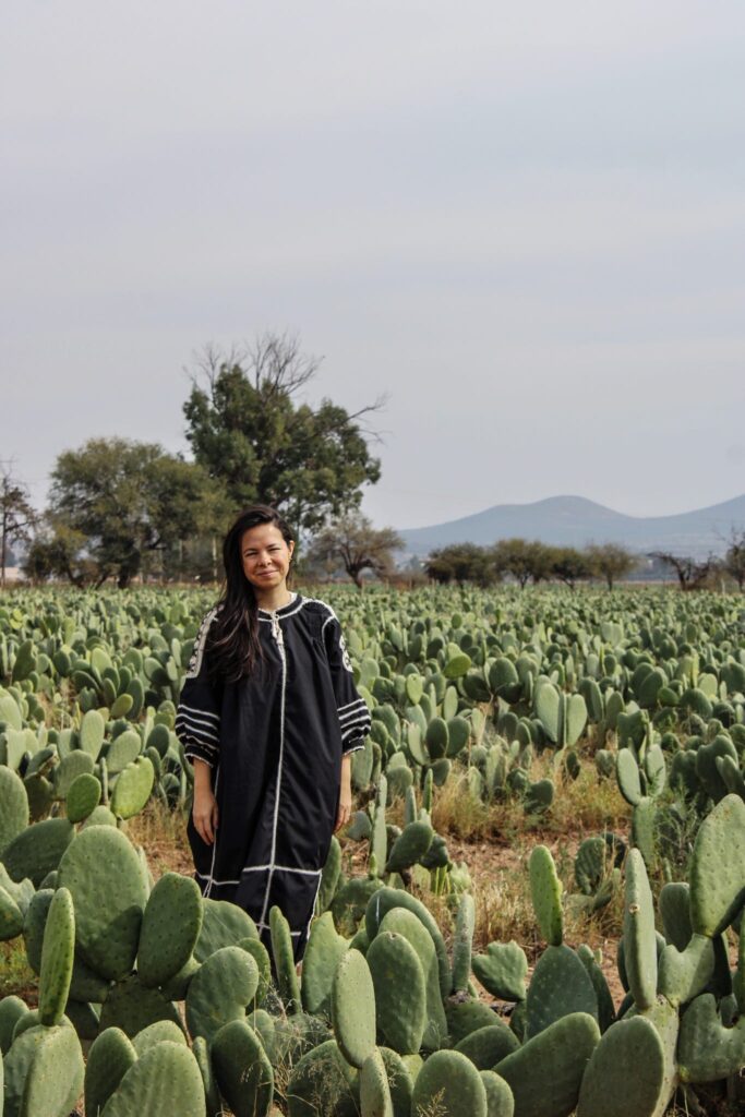Regina Trillo standing in a field of nopal cactus