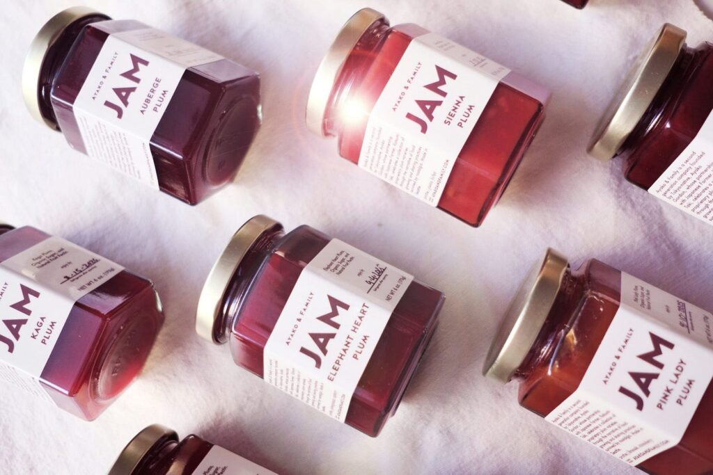 Jars of Ayako & Family plum jam on a white cloth