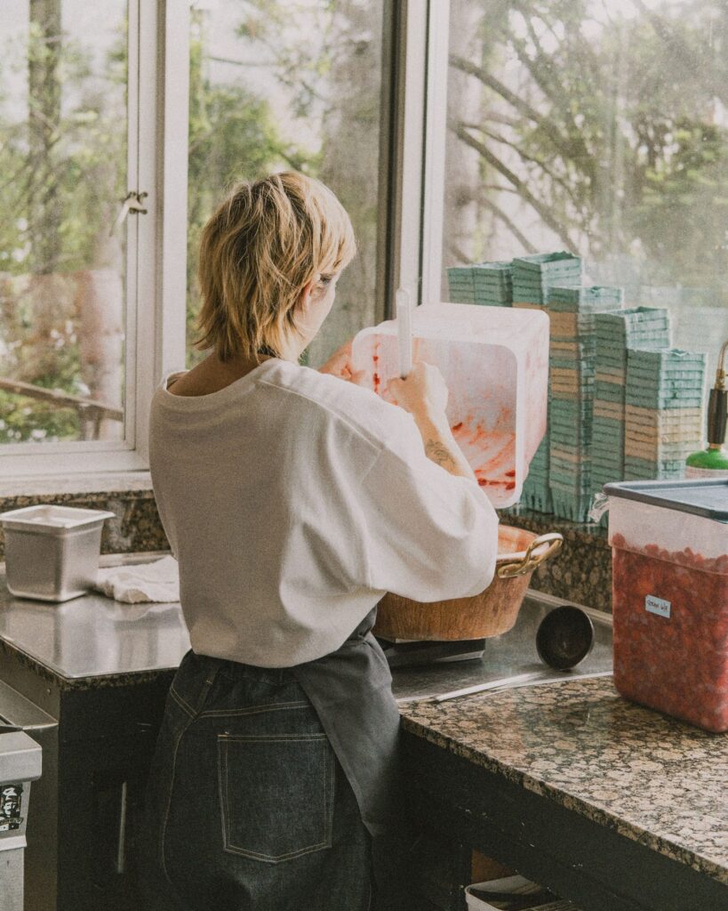 Sako Gordon preparing fruit at a kitchen counter by the window