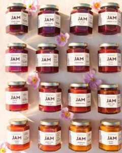 Rows of Ayako & Family plum jam jars with pink flowers
