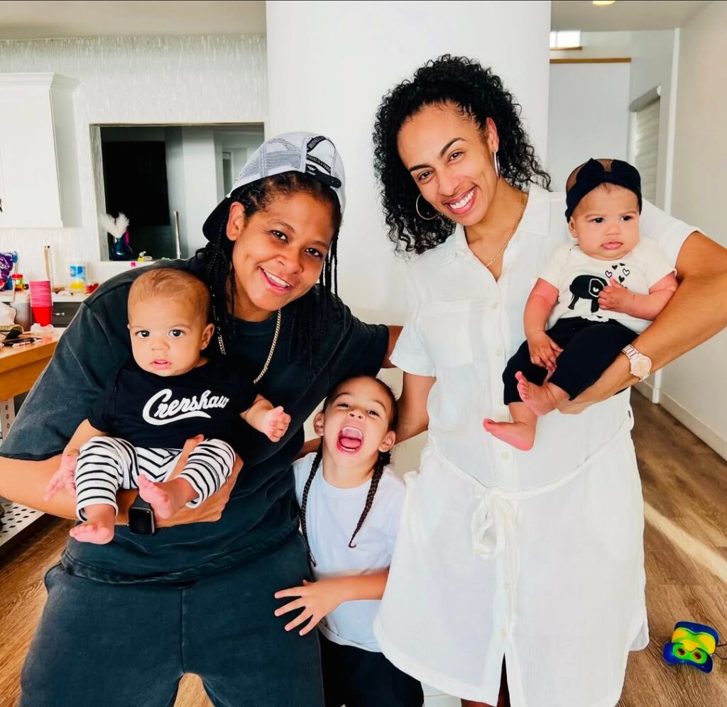 Chef Tashia stands smiling with her wife an 3 children