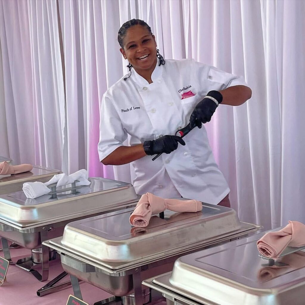 Chef Tashia stands behind silver buffet trays