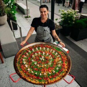 Chef Tatiana Rosana with a giant pan of paella