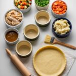 white ramekins filled with items for turkey pot pie, pie crust and utensils